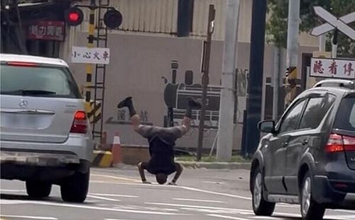平交道前練蛤蟆功！彰化阿伯倒立看火車 警將查證開罰
