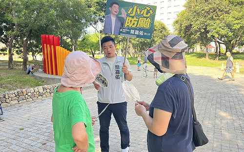 時事手舉牌力抗對手看板海 簡嘉佑：本人就在你面前
