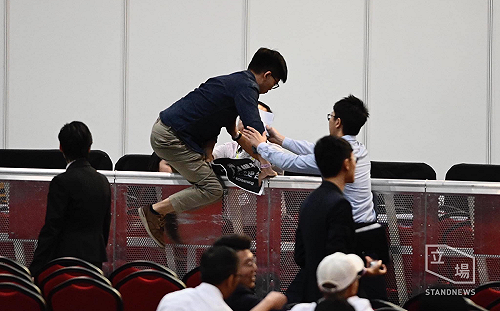 參選議員資格遲未被確認 黃之鋒衝向主席台抗議