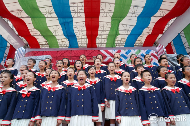 106年國慶預演，由甘惠忠神父帶領的南科實中國小部合唱團高唱國歌。   圖：張良一/攝
