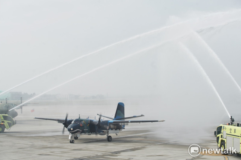 退役的空軍S-2T反潛機完成最後一趟飛行任務後，接受四輛消防車噴出水柱的致敬。   圖：張良一/攝