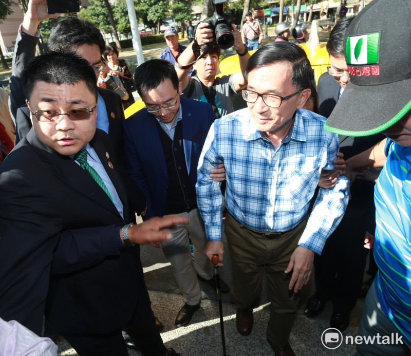 陳水扁今天在高雄市立圖書館舉辦簽書會，他搭乘計程車來到會場，拄著拐杖，在家人的攙扶下一步步走往圖書館，迎面而來的都是支持他的扁迷。   圖：新頭殼攝影組/攝影