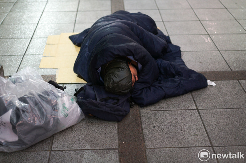 街友僅靠睡袋抵抗嚴寒雨夜。   圖：張良一/攝