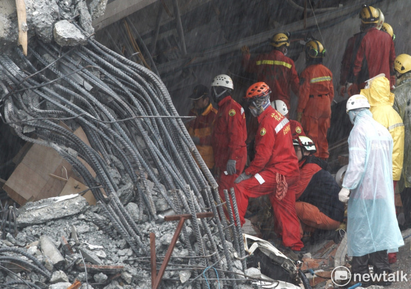 搜救進行到一半，天空卻下起雨來，搜救隊在瓦礫中，發現兩位罹難者。   圖：張良一/攝