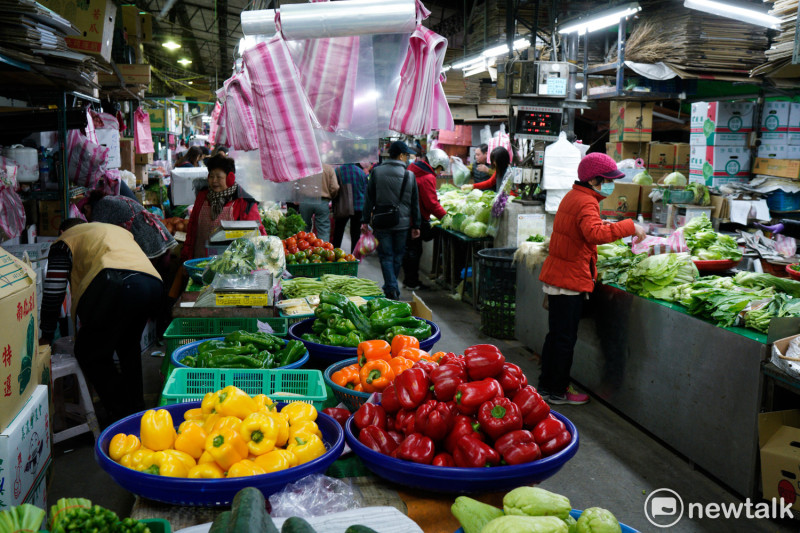 與台北農產公司第一果菜批發市場緊鄰的菜市場攤商，取得剛剛標購到的新鮮蔬菜，立刻整理上架，等待天亮後市民來採購。   圖：張良一/攝