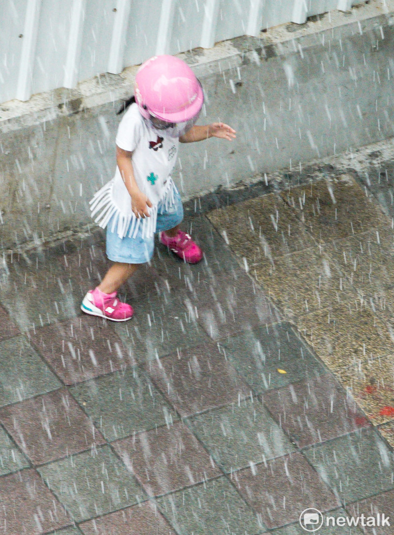大雨中躲雨的小女孩。   圖：張良一/攝