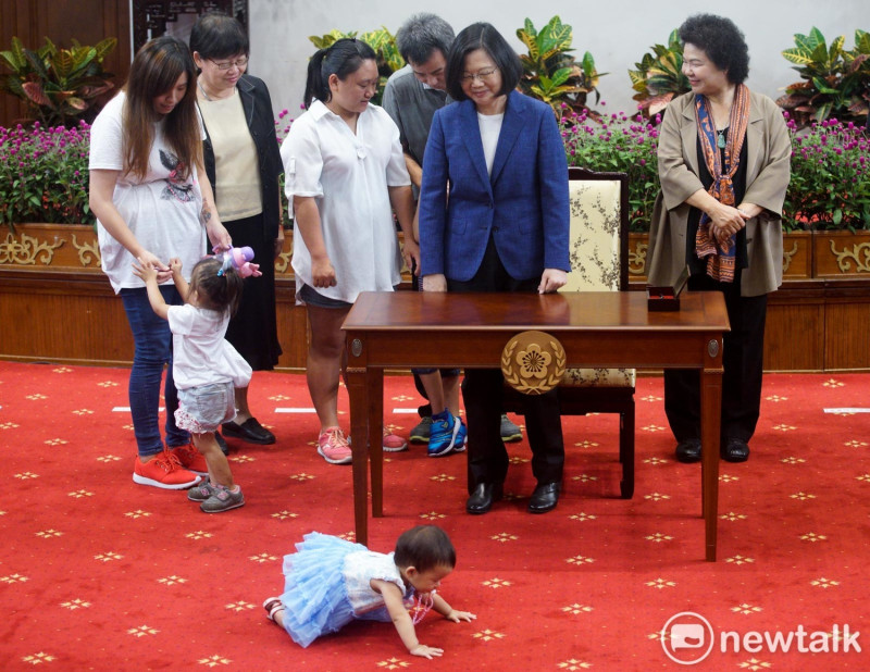 總統蔡英文出席「簽署『兒童及少年未來教育與發展帳戶條例』記者會，一位小朋友在會場自顧自的爬行，引起眾人的注目。   圖：張良一/攝
