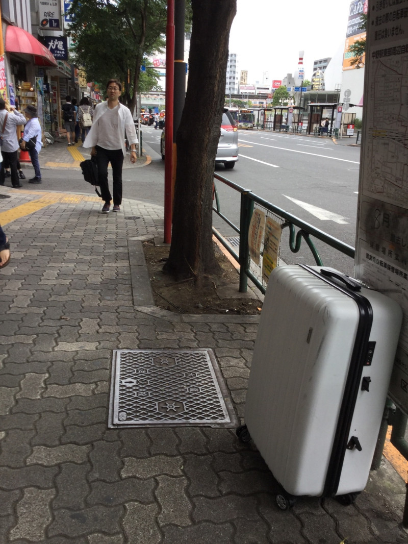 東京鬧區或住宅區也都開始出現廢棄行李箱。   圖：劉黎兒攝