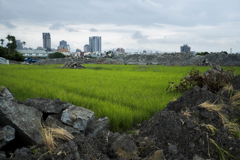 台中市南屯區一處稻田旁堆滿廢棄土石，由於這片農地被變更為都市重畫區，已經無法再種作。   圖：張良一 /攝