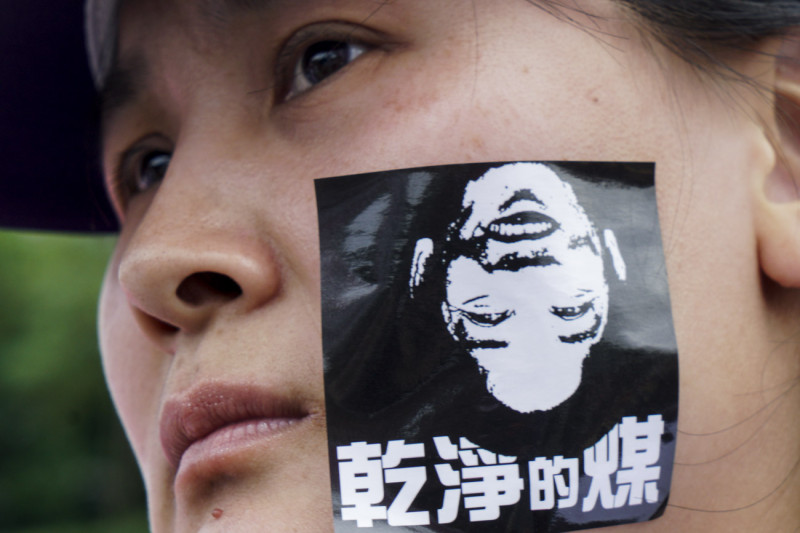 一位參與遊行在臉上貼著「健康的媒」和賴清德頭像的貼紙。   圖：張良一/攝