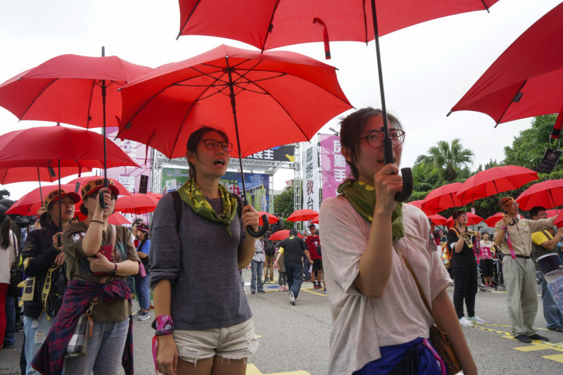 參與遊行民眾撐著紅傘擺出的投票章圖形，並呼喊反空污口號。   圖：張良一/攝