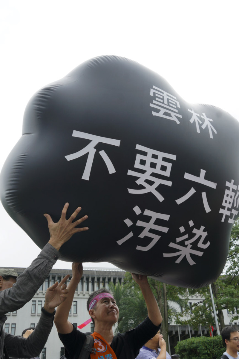 雲林縣長參選人王麗萍頭頂空污污雲造型參與遊行。   圖：張良一/攝