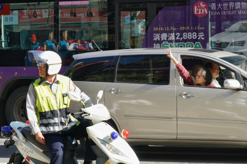 國民黨台北市長候選人丁守中上午在中正、萬華區掃街時，時，一位支持者搖下車窗向丁比出二號手勢。   圖：張良一/攝