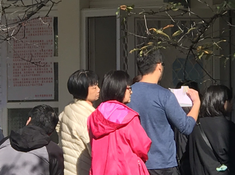 新北市淡水區鄧公國小投票所，等待投票的民眾。   圖：朱蒲青／攝