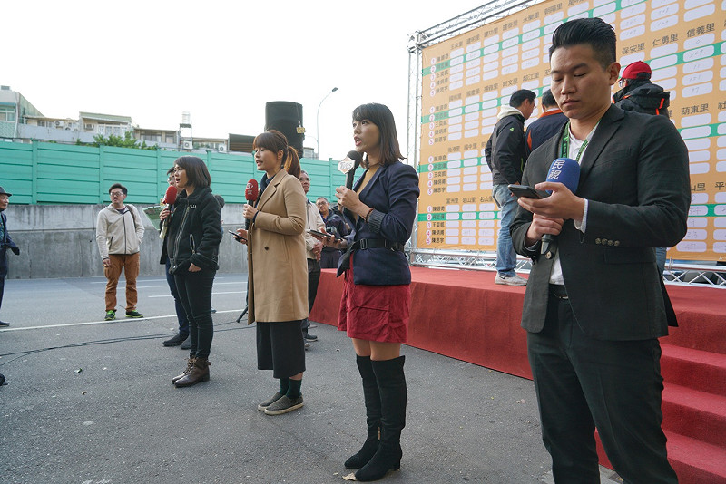 媒體在何志偉競選總部外報導北市士林、大同區立委補選，民進黨的何志偉暫時領先國民黨的陳炳甫。   圖：張良一/攝