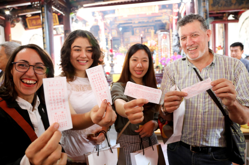 外國旅客抽籤體驗在地宗教文化樂趣。   圖：台南市政府第二官方語言辦公室/提供