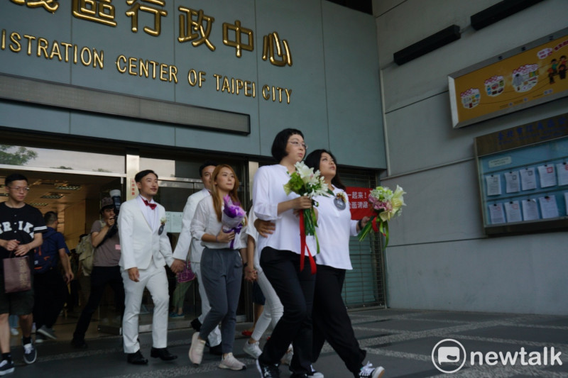 多對同性伴侶在台北市信義區戶政事務所辦完結婚登記後，一起步出信義行政中心。   圖：張良一 / 攝