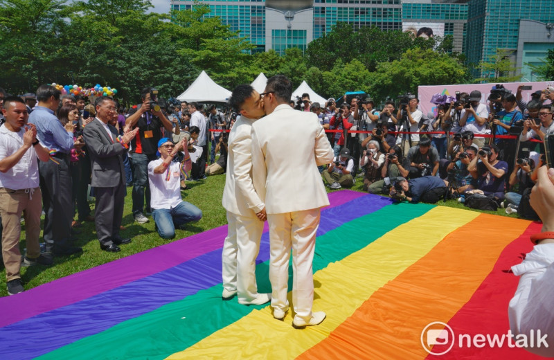 同婚登記24日開跑，同婚團體婚姻平權大平台在戶外舉辦「幸褔起跑線Wedding Party」，同志新人以彩虹旗當作紅毯步入會場。   圖：張良一/攝