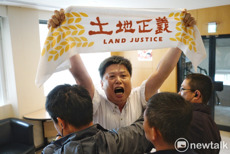 政大教授徐世榮高舉「土地正義」布條在賴清德記者會外抗議。   圖：張良一 / 攝