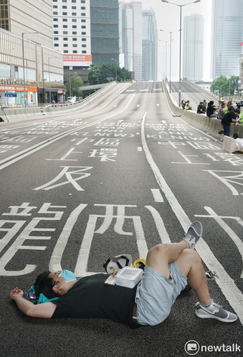一位香港青年在政府總部前躺下，在已經封閉的夏慤道上休息。   圖：張良一/攝