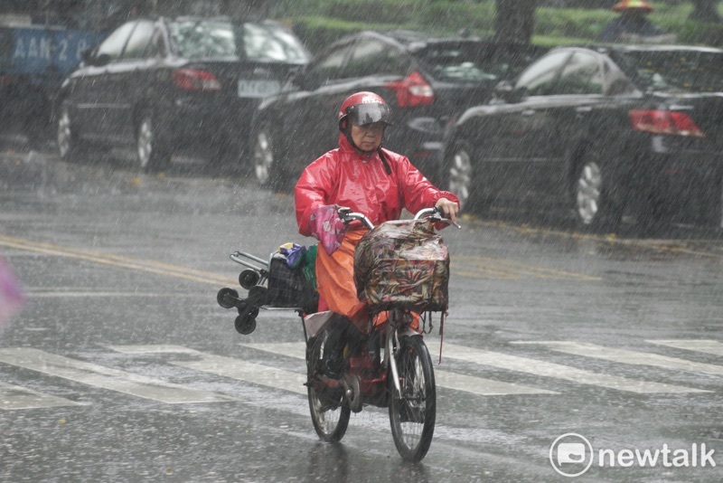 利奇馬颱風來襲，台北市區仍有長者在大雨中騎車。   圖：張良一/攝