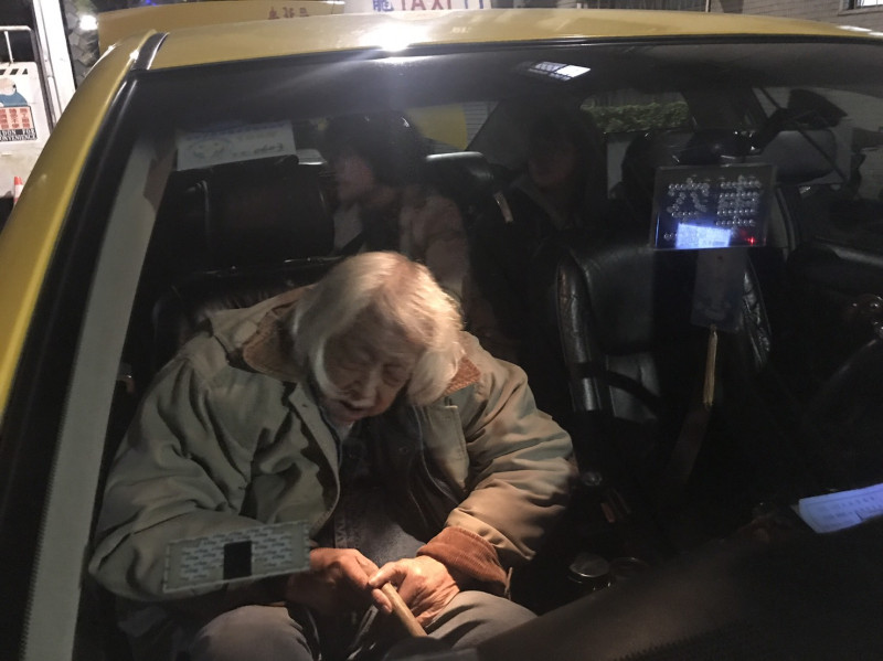 坐進計程車車內的史明。在燈光下，老人家的身影顯得十分清晰。   圖：朱蒲青/攝
