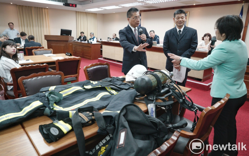 內政部長徐國勇、消防署長陳文龍在立院內政委員會和立委劉世芳共同檢視消防員的個人裝備。   圖：張良一/攝