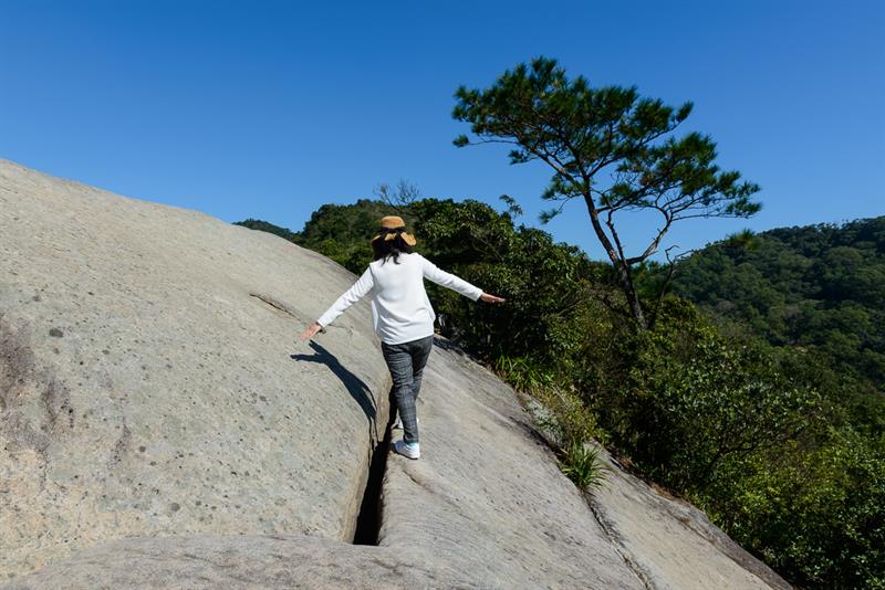 人趴在石頭上，轉個角度就可以拍出假裝垂直攀岩的驚險照片。圖：翻攝自農業易遊網