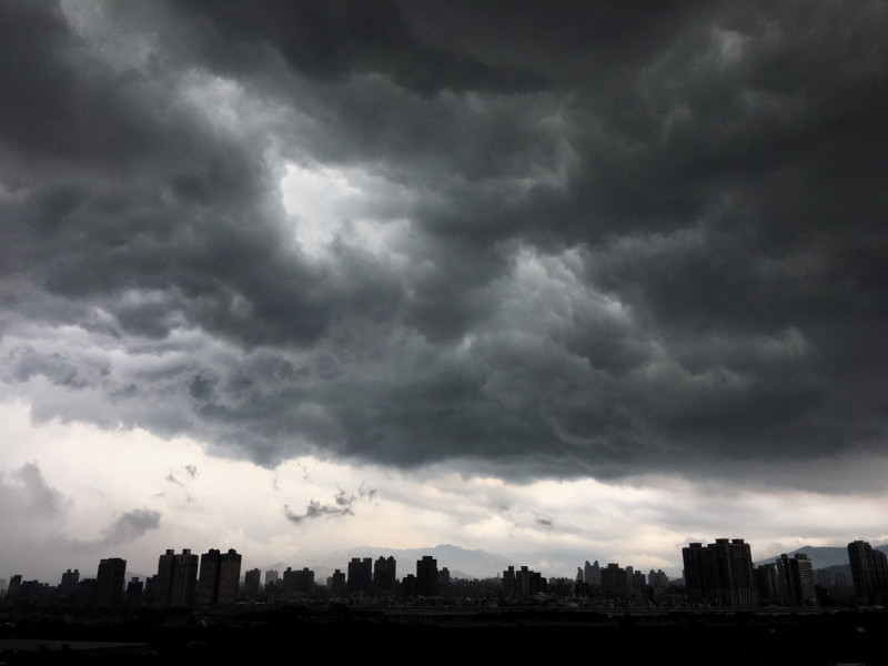 台北上空下午烏雲密佈雷聲大作，部份地區也下起大雨。   圖：張良一/攝