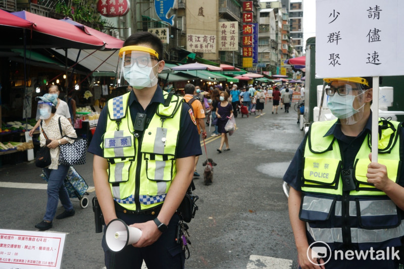 警察大陣仗的在台北濱江市場站崗，要求民眾在市場採買後速離去勿群聚。   圖：張良一/攝