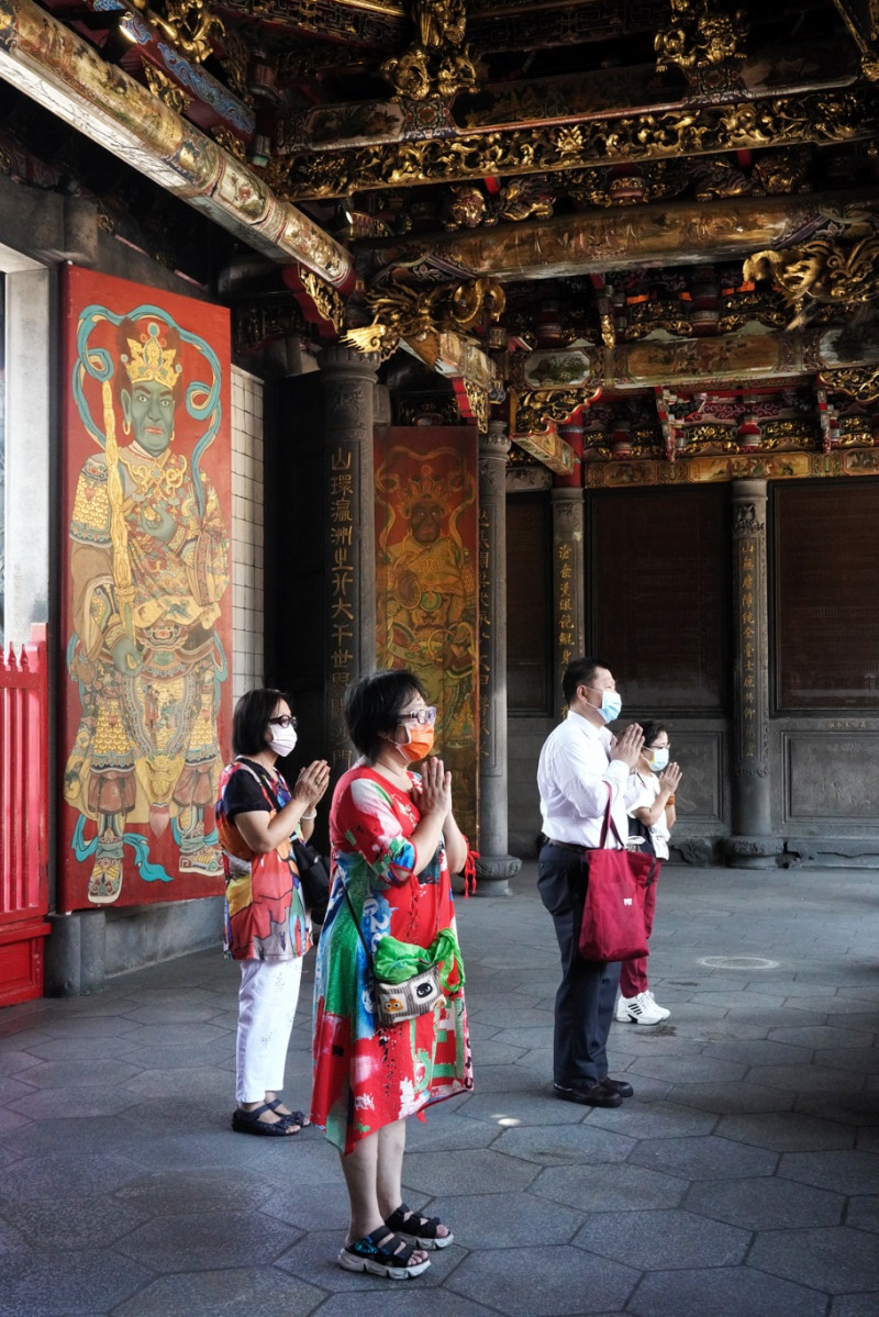 疫情警戒從三級降為二級的首日，萬華龍山寺也重新開放，供信眾入內參拜。   圖：張良一/攝