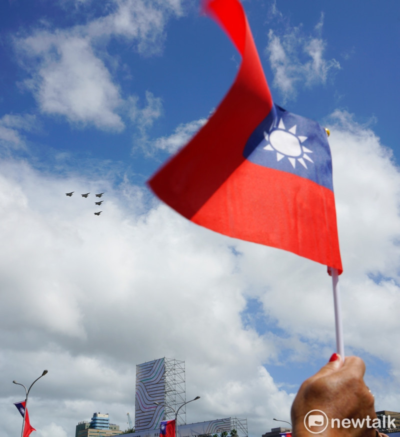 圖為空軍幻象2000-5戰機以大雁隊形通過總統府上空，參加國慶大會的僑胞揮國旗致意。   圖：張良一/攝（資料照）