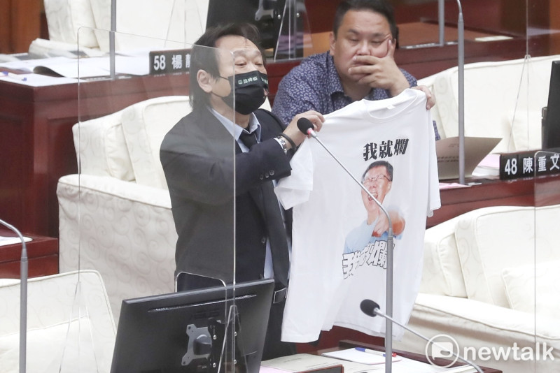 民進黨籍台北市議員王世堅在市議會質詢時，送「我就爛」T-shirt給台北市長柯文哲。   圖：張良一 / 攝