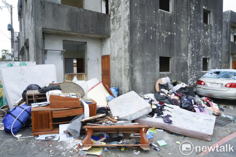 已經清空的房子外被人棄置從外地載來廢棄傢俱、彈簧床墊。   圖：張良一/攝