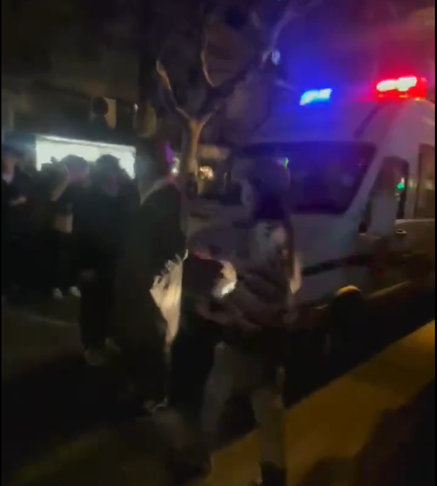 一名青年阻擋在救護車前，隨即被警察強制架離。   圖：翻攝自推特