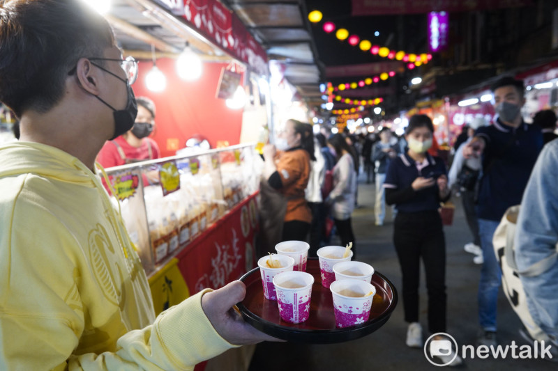 台北年貨大街上的攤商端出各種試吃和試喝飲品讓市民嚐鮮。   圖：張良一/攝