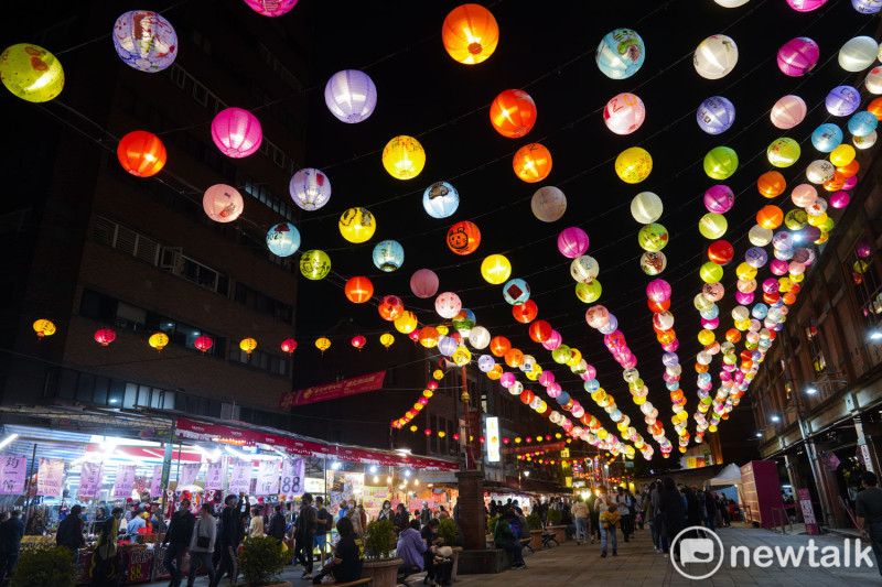 台北永樂市場外懸掛五彩的燈籠與迪化街上的台北年貨大街相互輝印，璀璨的燈光與採購年貨、逛大街的人潮讓台北年貨大街充滿著節慶氛圍。   圖：張良一/攝