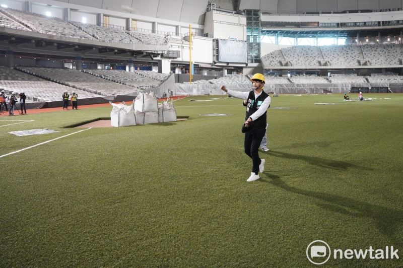 台北市議會教育委員會議員上午考察大巨蛋球場草皮施工情況，圖為市議員在球場內試投球。   圖：張良一 / 攝