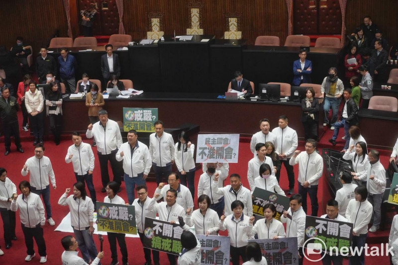 立院國民黨團今欲強行闖關選罷法修正草案，民進黨籍立委一早即佔據主席台，阻擾會議進行。圖為國民黨立委在議場內舉牌抗議民進黨不開會搞戒嚴。   圖：張良一/攝
