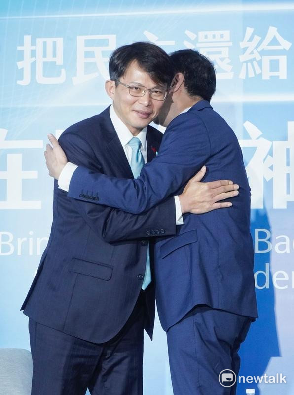 國民黨主席朱立倫、民眾黨主席黃國昌在「把民主還給台灣 在野領袖峰會」相互擁抱。   圖：張良一 / 攝