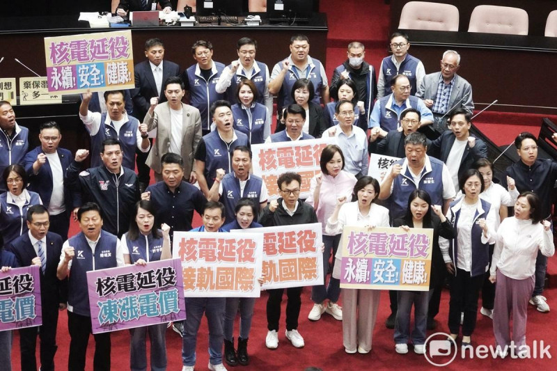 國民黨立委在立法院院長韓國瑜在院會敲鎚三讀通過核管法第六條文修正草案。高舉起「核能延役 接軌國際」牌子喊口號挺核電延役。 圖:張良一/攝