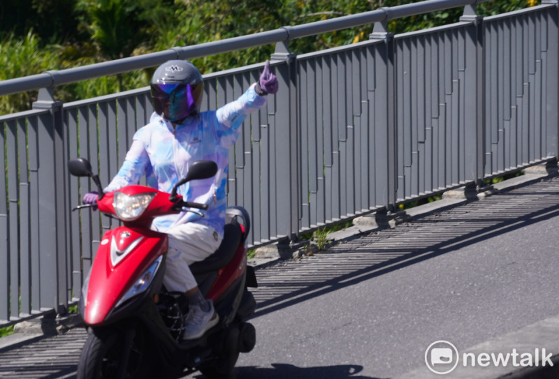一位機車騎士在花東縱谷公路對著護國大遶境車隊豎起大拇指。 圖:張良一/攝