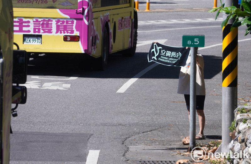 一位民眾在花東縱谷公路拿著台灣獨立鯨魚旗,呼應護國大遶境車隊。 圖:張良一/攝