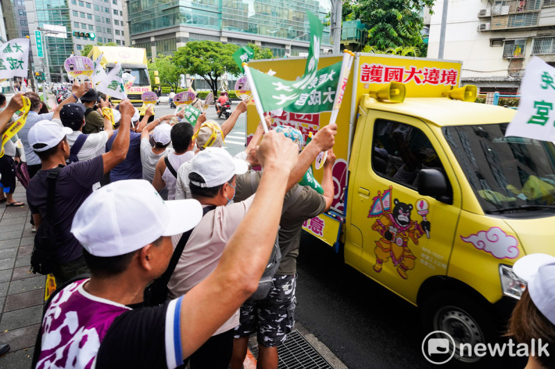 護國大遶境掃街車隊今午來到北市南港、內湖區向市民拜票，支持罷免國民黨立委李彥秀的內湖區民眾站在路口，手持大罷免大成功旗幟呼應。   圖：張良一/攝