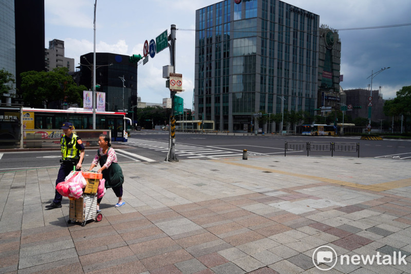 台北市今進行「2025城鎮韌性演習」，首度整合「民安」與「萬安」兩項演習，當防空警報響起時，在西門町商圈的民眾陸續進入店家或是充當防空避難所的捷運站內，圖為一位警察協助民眾進入防空避難所。   圖：張良一/攝