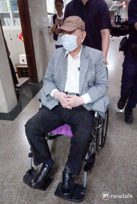 威京集團主席沈慶京搭輪椅戴電子腳鐐前往台北地方法院。   圖：張良一/攝