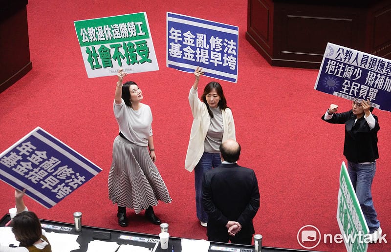 立法院院會今三讀通過年改法案：「公務人員退休撫卹法第37、38、67條條文修正草案。民進黨立委在表決前各自舉牌表訴立場。   圖：張良一/攝