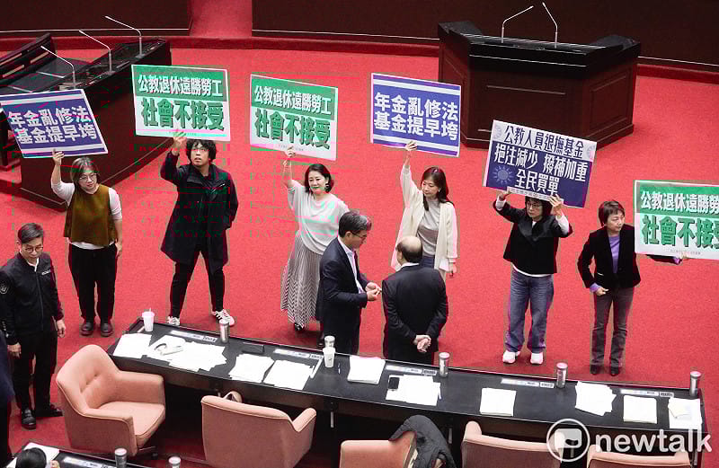 立法院院會今三讀通過年改法案：「公務人員退休撫卹法第37、38、67條條文修正草案。民進黨立委在表決前各自舉牌表訴立場。   圖：張良一/攝