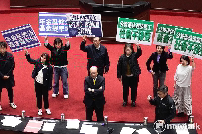 立法院院會今三讀通過年改案修正草案後，朝野立委各自舉牌表述立場。   圖：張良一/攝