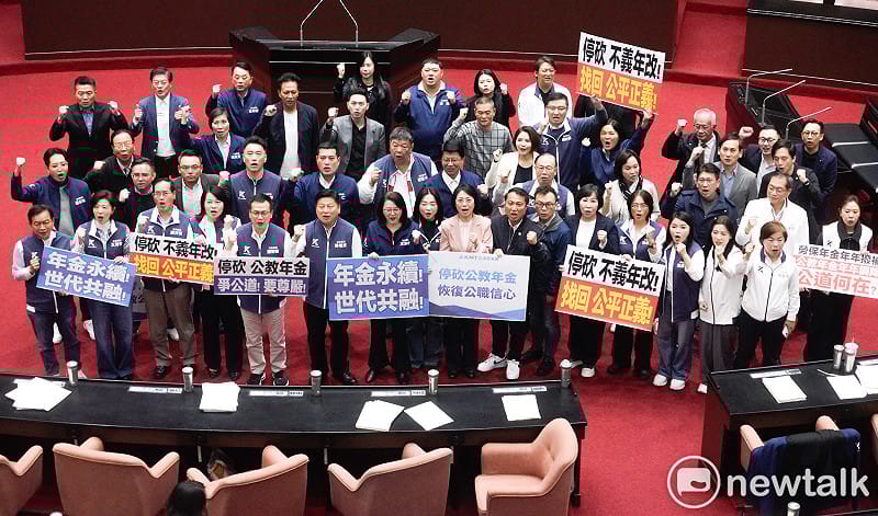 立法院院會今三讀通過年改案修正草案後，朝野立委各自舉牌表述立場。   圖：張良一/攝